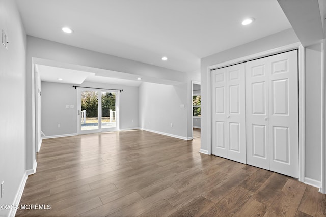 unfurnished bedroom featuring access to exterior, wood finished floors, and recessed lighting