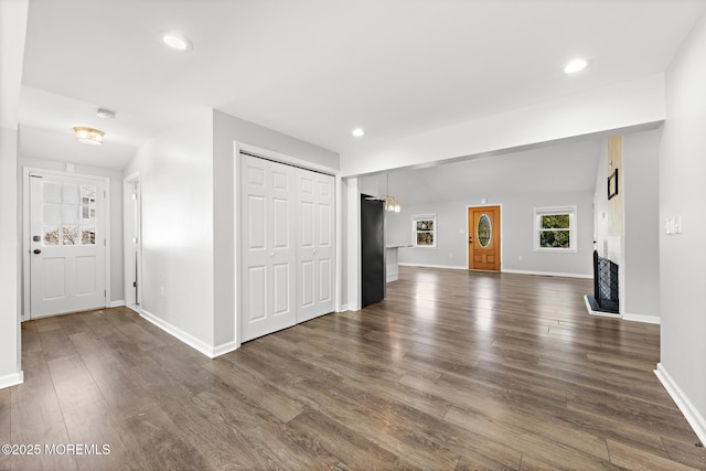 unfurnished living room featuring dark wood-style floors, recessed lighting, and baseboards