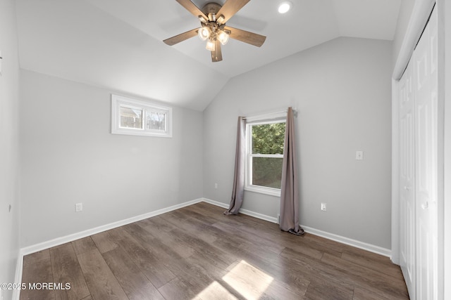 unfurnished bedroom with lofted ceiling, ceiling fan, wood finished floors, baseboards, and a closet