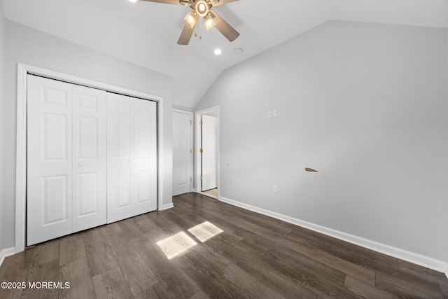 unfurnished bedroom with baseboards, vaulted ceiling, and dark wood-style flooring