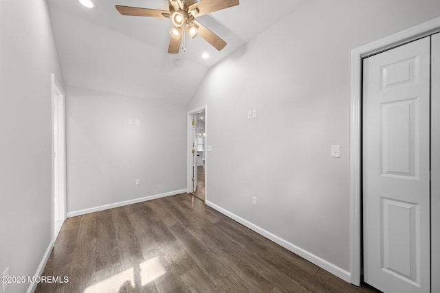 interior space featuring lofted ceiling, a ceiling fan, baseboards, and wood finished floors