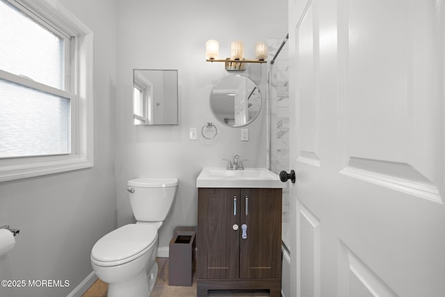 bathroom featuring baseboards, vanity, and toilet