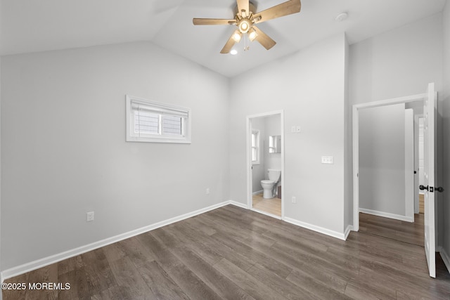 unfurnished bedroom with ceiling fan, ensuite bathroom, lofted ceiling, baseboards, and dark wood-style floors