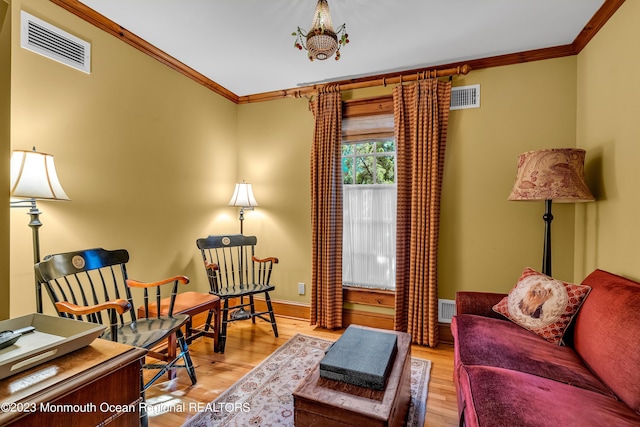 living room featuring visible vents, wood finished floors, and ornamental molding