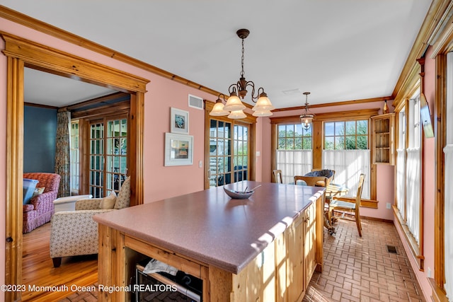 dining area with a notable chandelier, visible vents, and crown molding