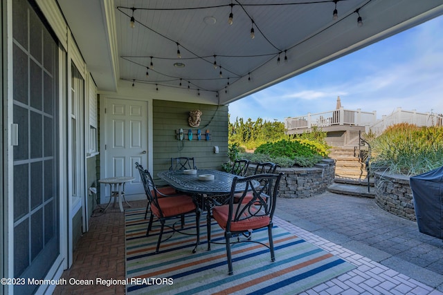 view of patio with outdoor dining space and stairway