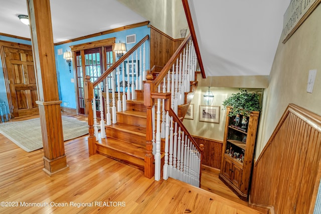 stairs featuring crown molding, decorative columns, visible vents, and wood finished floors