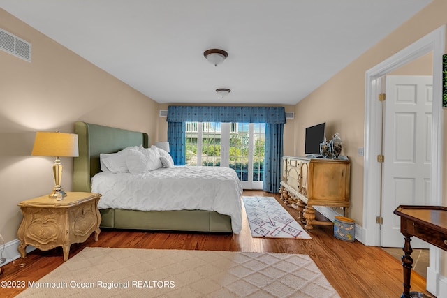 bedroom featuring baseboards, visible vents, and wood finished floors