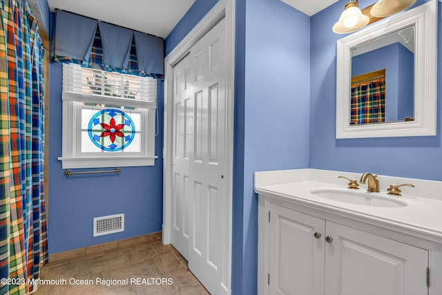 full bath featuring baseboards, visible vents, and vanity