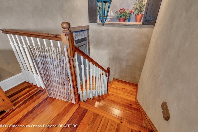 staircase with hardwood / wood-style floors