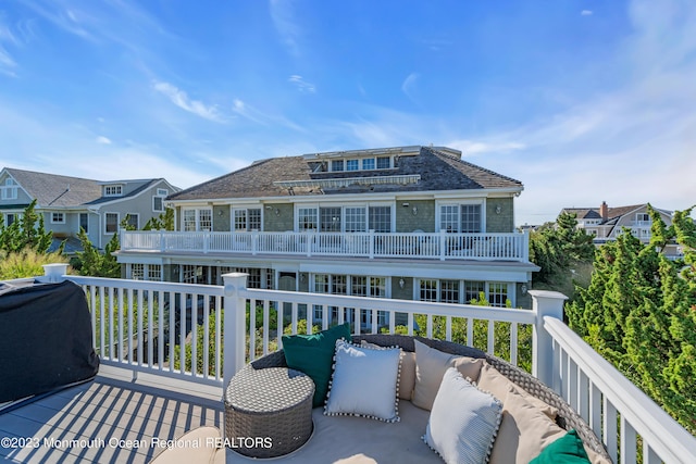 back of property featuring a balcony and an outdoor hangout area