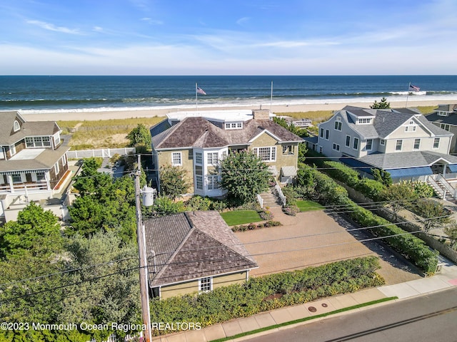 drone / aerial view with a water view and a beach view