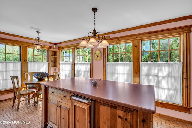 kitchen featuring brick floor, pendant lighting, brown cabinets, crown molding, and a kitchen island