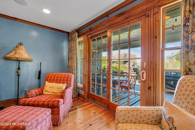 living area featuring ornamental molding and hardwood / wood-style flooring