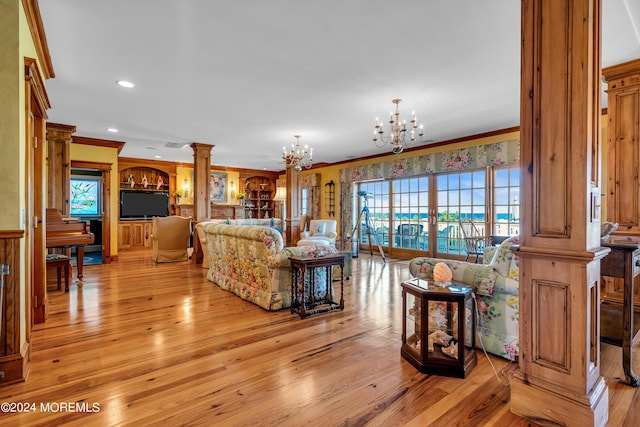 living room with decorative columns, crown molding, light wood-style floors, a notable chandelier, and recessed lighting