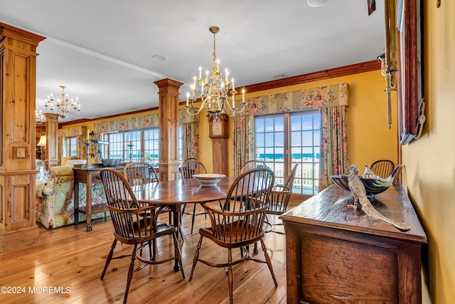 dining area with a chandelier, a wealth of natural light, decorative columns, and ornamental molding