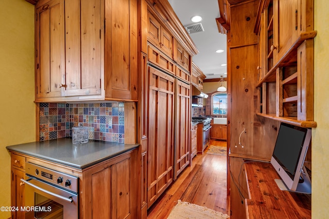 kitchen featuring stainless steel appliances, brown cabinetry, and dark countertops