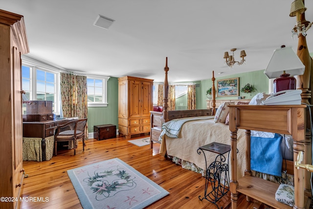 bedroom with light wood-style floors and a chandelier