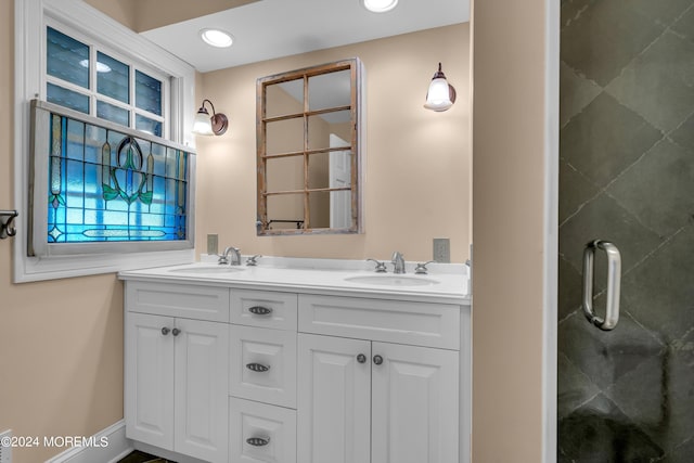 bathroom featuring double vanity, a shower stall, a sink, and recessed lighting