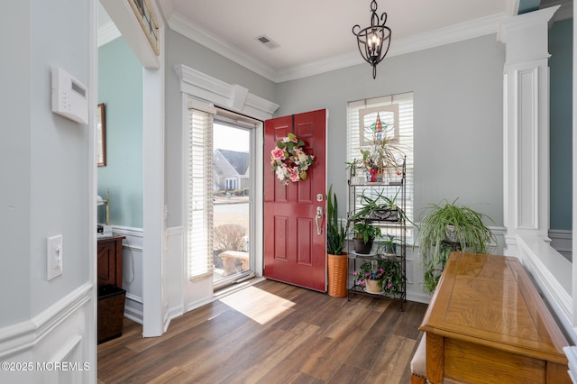 foyer entrance with a healthy amount of sunlight, wood finished floors, visible vents, and crown molding