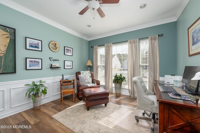 office space featuring ornamental molding, wainscoting, wood finished floors, and a ceiling fan