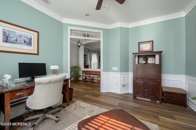 office area featuring arched walkways, a wainscoted wall, ornamental molding, ceiling fan, and wood finished floors