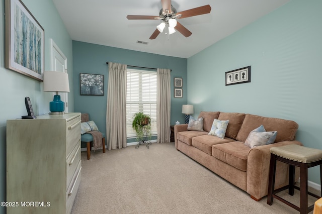 living area with light carpet, ceiling fan, visible vents, and baseboards