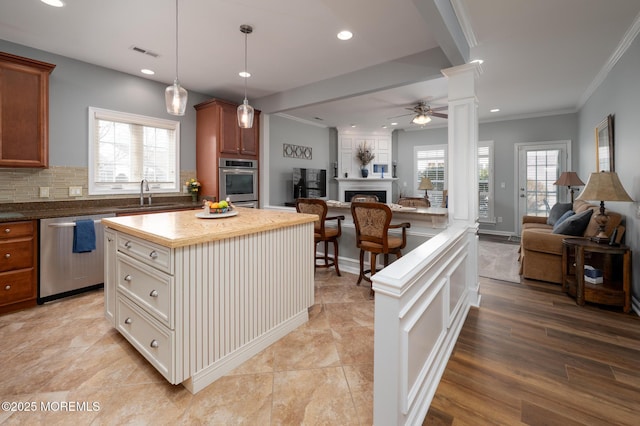 kitchen featuring a sink, visible vents, open floor plan, and dishwasher