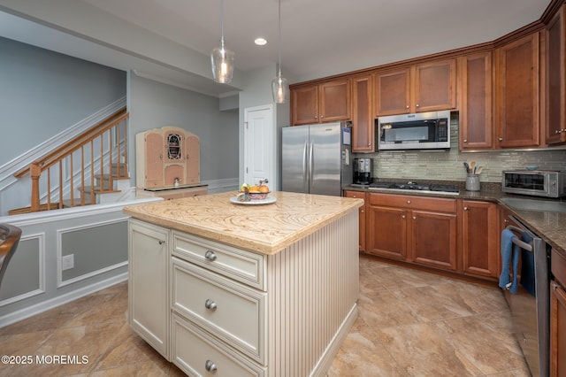 kitchen with appliances with stainless steel finishes, dark stone counters, a center island, and tasteful backsplash