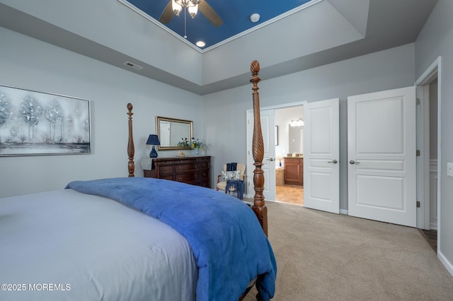 bedroom featuring ensuite bathroom, carpet, a raised ceiling, and visible vents