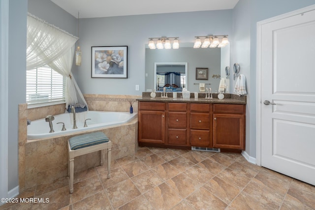 full bath with a sink, double vanity, a garden tub, and visible vents