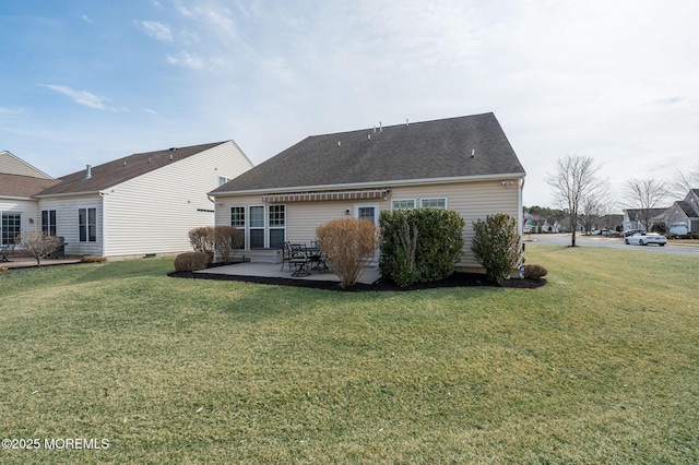 rear view of house featuring a patio area, a shingled roof, and a yard