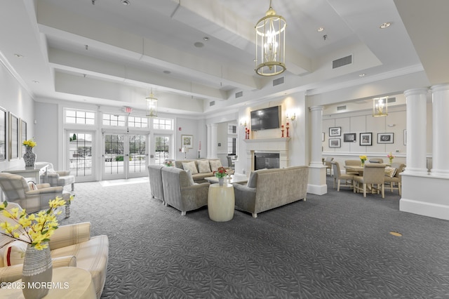 living room featuring french doors, dark carpet, a glass covered fireplace, and ornate columns