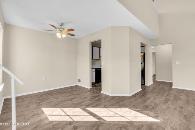 unfurnished room with a ceiling fan, baseboards, and wood finished floors