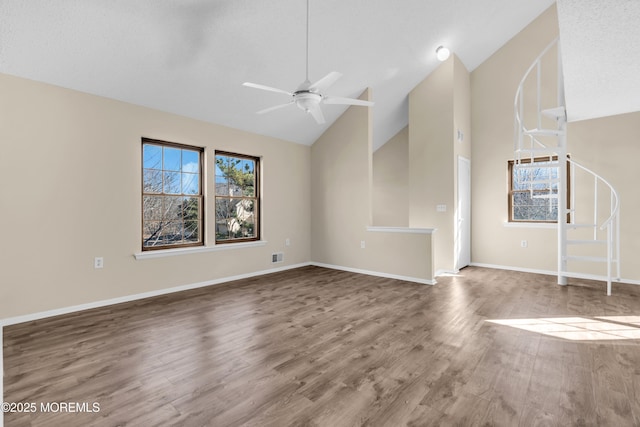 unfurnished living room with visible vents, a ceiling fan, wood finished floors, high vaulted ceiling, and baseboards