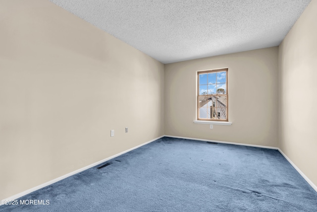 spare room with baseboards, visible vents, a textured ceiling, and carpet flooring