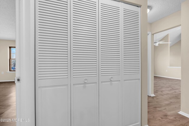 interior details featuring ceiling fan, baseboards, a textured ceiling, and wood finished floors