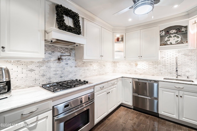 kitchen featuring dark wood-style floors, appliances with stainless steel finishes, glass insert cabinets, white cabinetry, and a sink