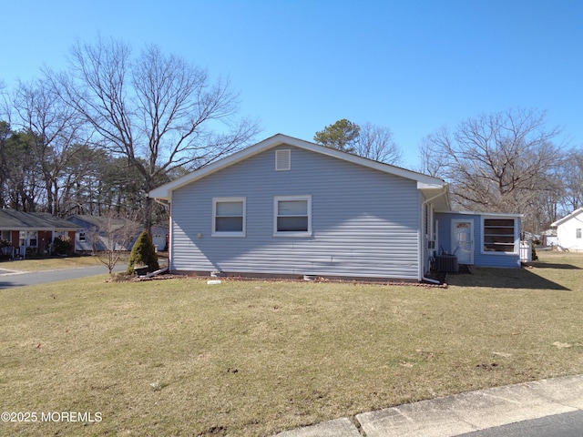 view of side of home with a lawn and cooling unit