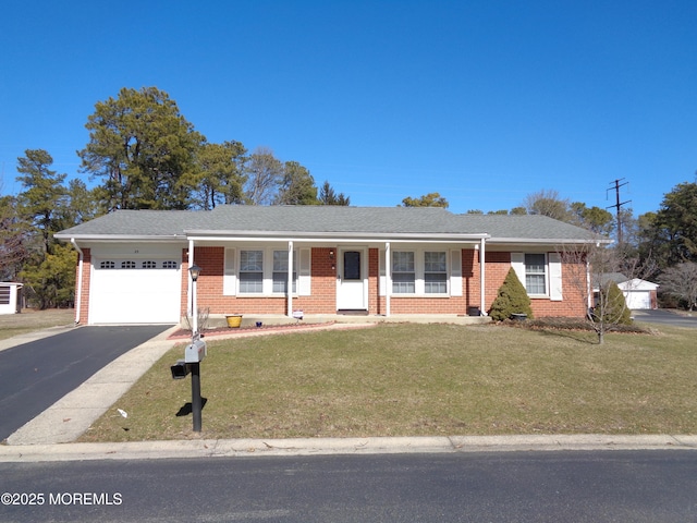 ranch-style home featuring aphalt driveway, a garage, brick siding, and a front yard