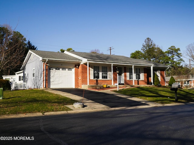 ranch-style house featuring roof with shingles, an attached garage, a front lawn, aphalt driveway, and brick siding