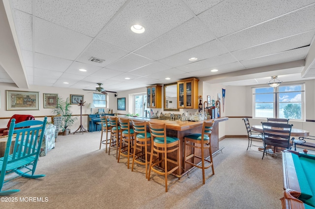 carpeted dining room featuring recessed lighting, indoor wet bar, visible vents, and a drop ceiling