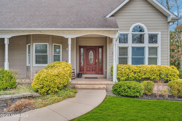 property entrance with covered porch and a shingled roof