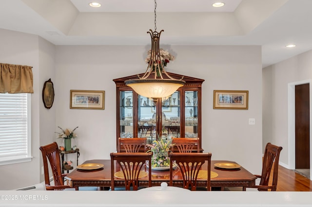 dining room featuring a tray ceiling, recessed lighting, and wood finished floors