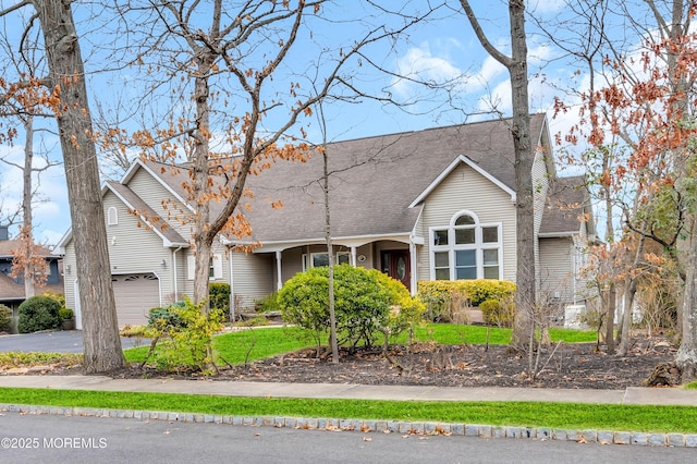view of front of property featuring an attached garage, driveway, and roof with shingles