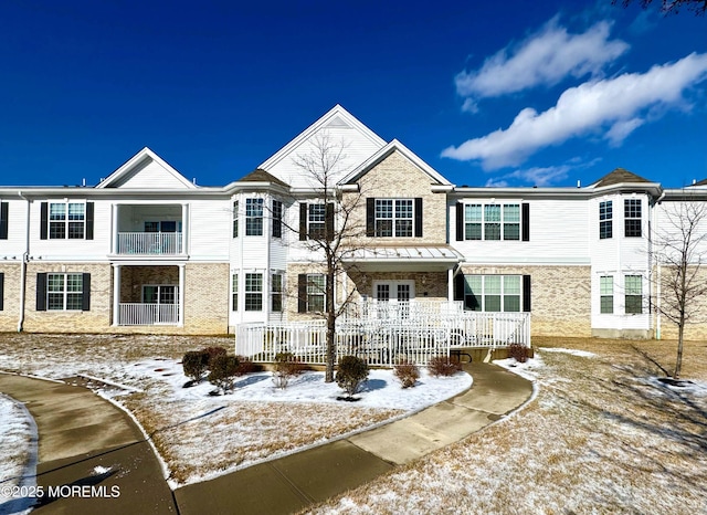 multi unit property featuring a porch and brick siding