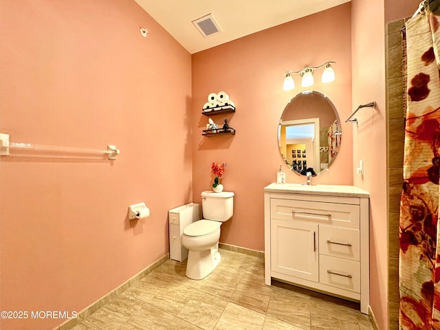 bathroom featuring visible vents, baseboards, vanity, and toilet