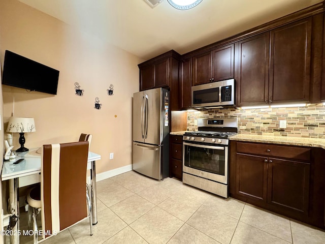 kitchen with dark brown cabinets, appliances with stainless steel finishes, light tile patterned flooring, and tasteful backsplash