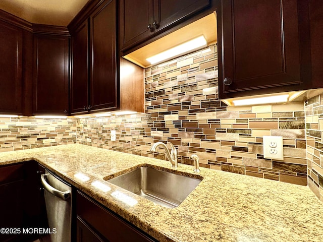 kitchen with dark brown cabinets, tasteful backsplash, a sink, and light stone counters