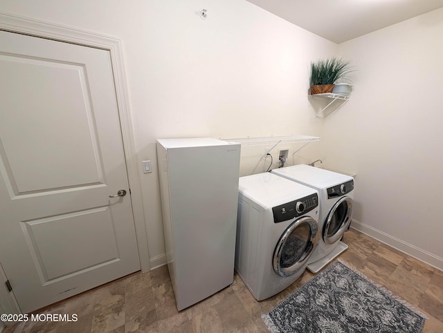 laundry room featuring baseboards, laundry area, and washer and dryer